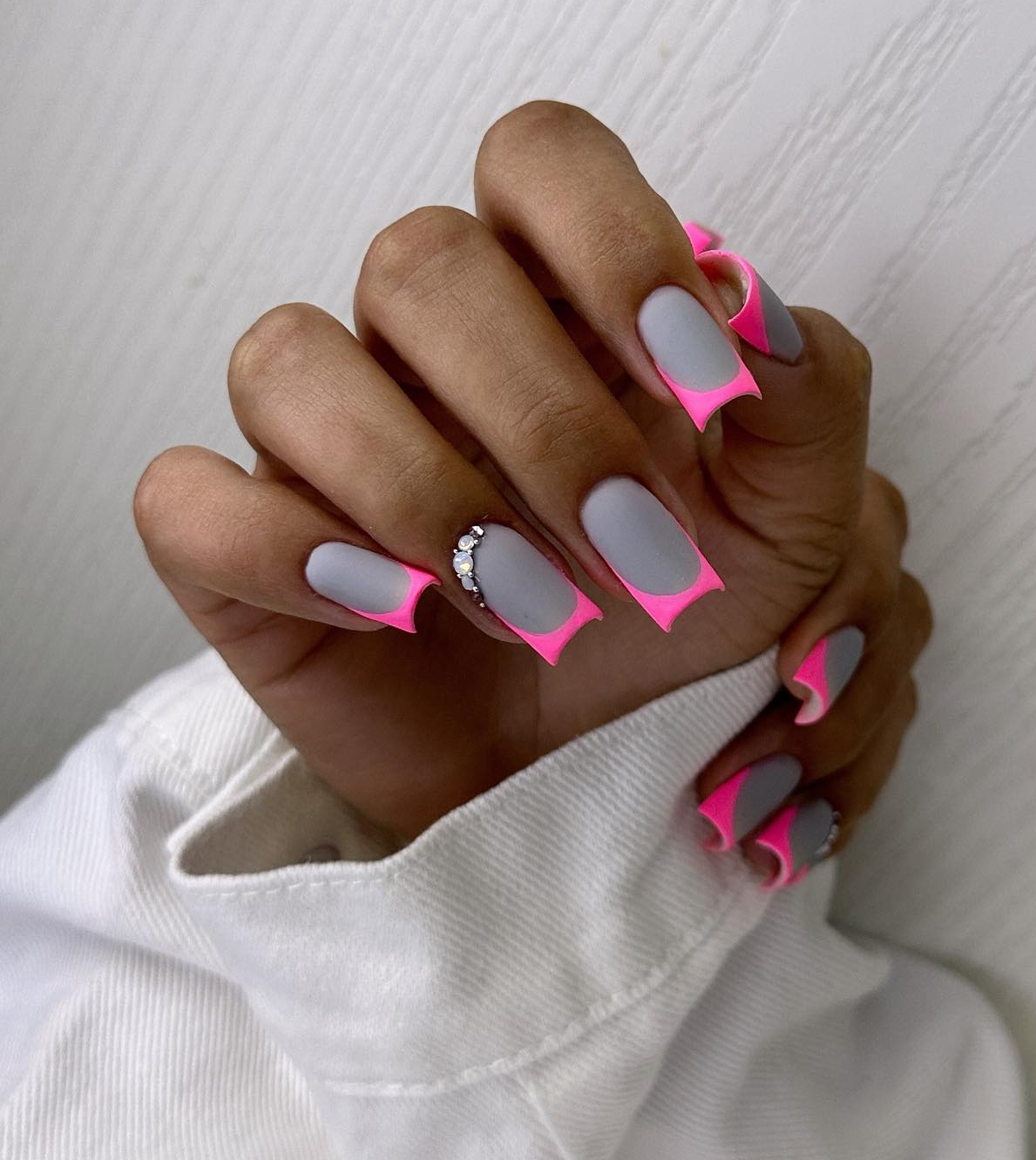 Uñas grises mate con puntas rosa eléctrico