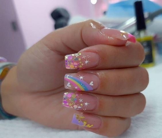 277 Nails with short square stars with nude enamel design of stars and circles in white gold and pink rainbow stars and hearts on the middle finger